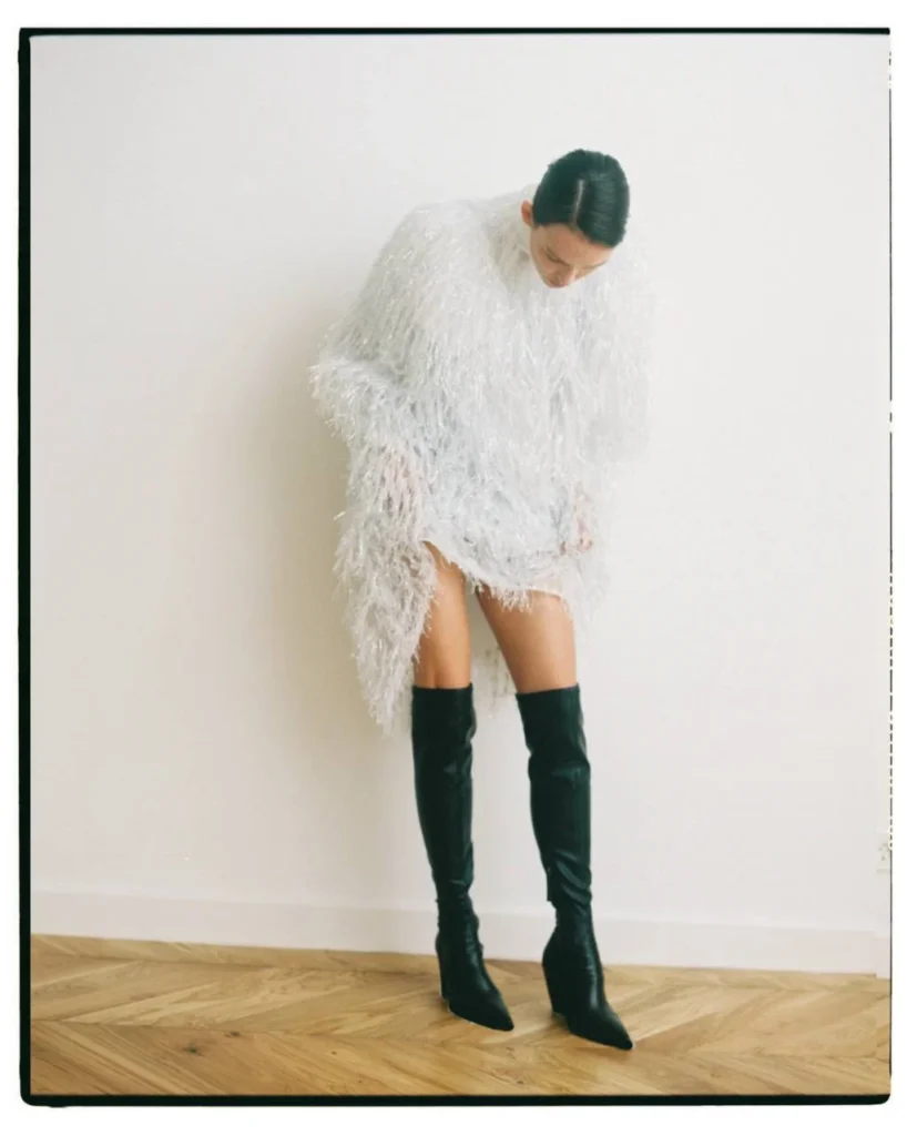 Паулина Андреева снялась в мини-платье с перьями и высоких ботфортах